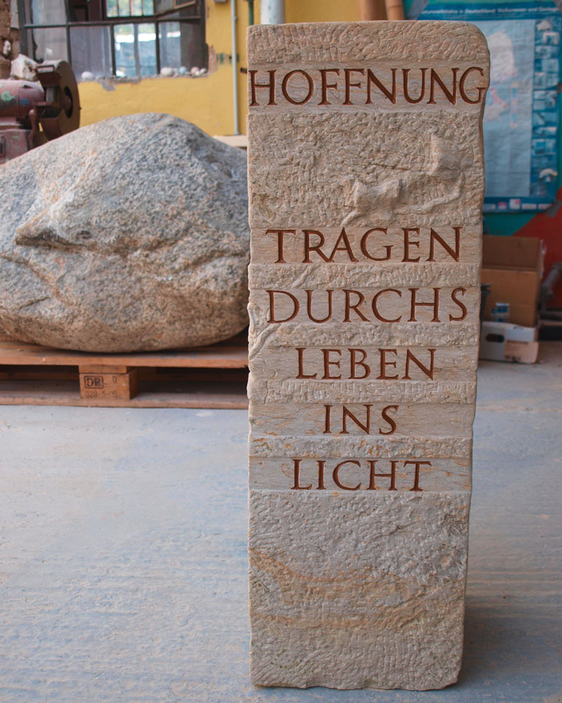 Erinnerungszeichen für einen Naturfreund, Efeuranken und Text umwinden den Cottaer Sandstein, im Kopf befindet sich eine Vogeltränke, Einfassung aus Edelstahlband Friedhof Wandlitz